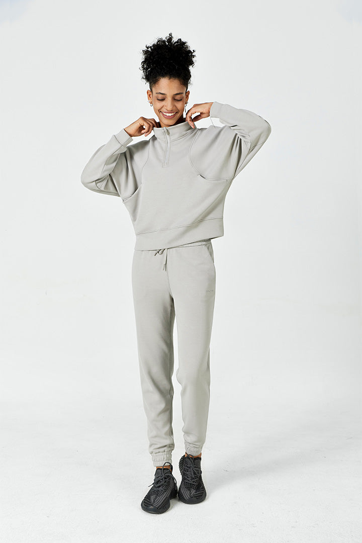 Full body view of a woman wearing a soft half zip pullover and jogger set