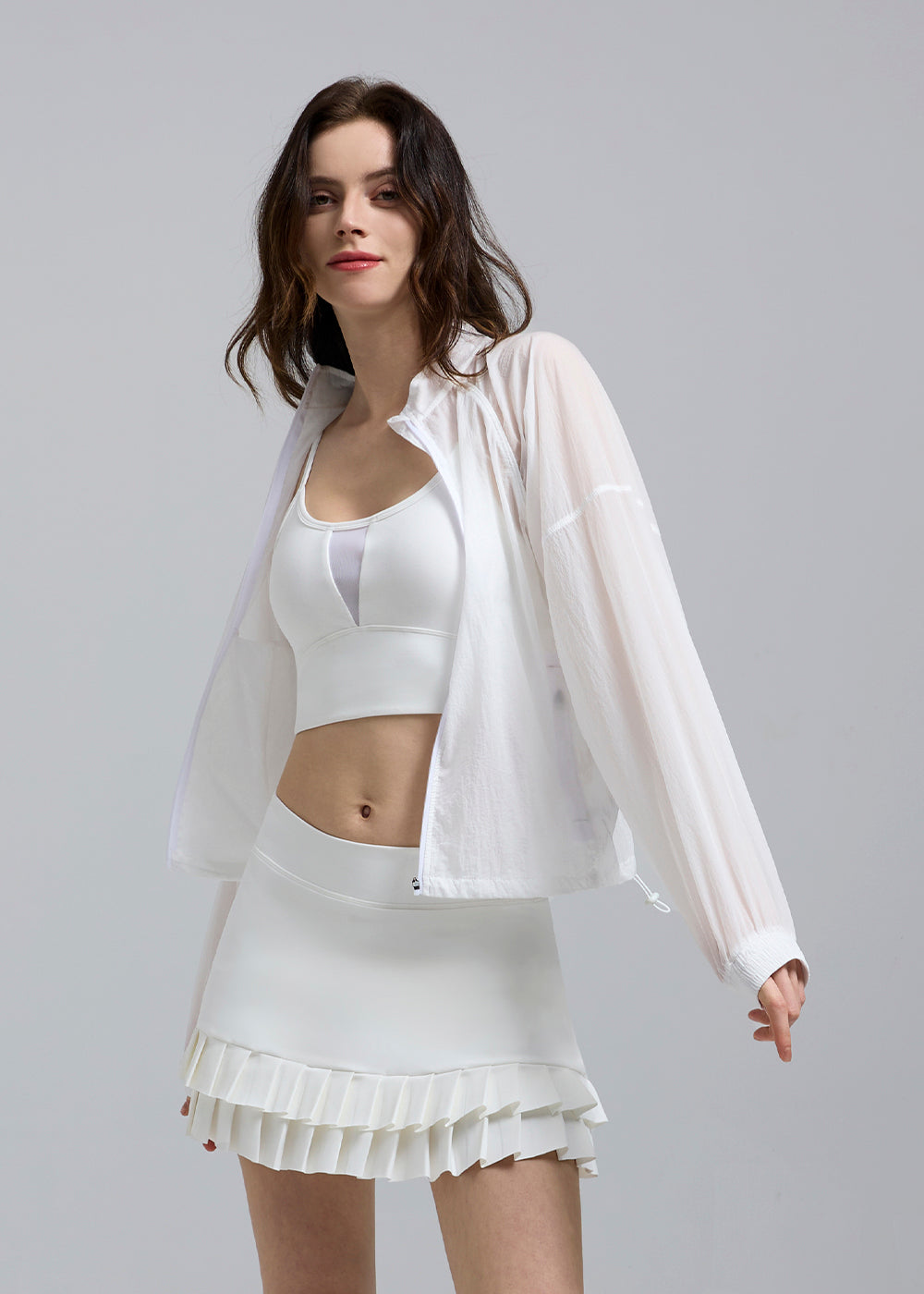 woman wearing a Saltum white UV jacket and tennis activewear