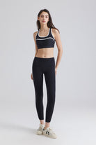 Saltum Woman wearing a black sports bra and leggings with white sneakers