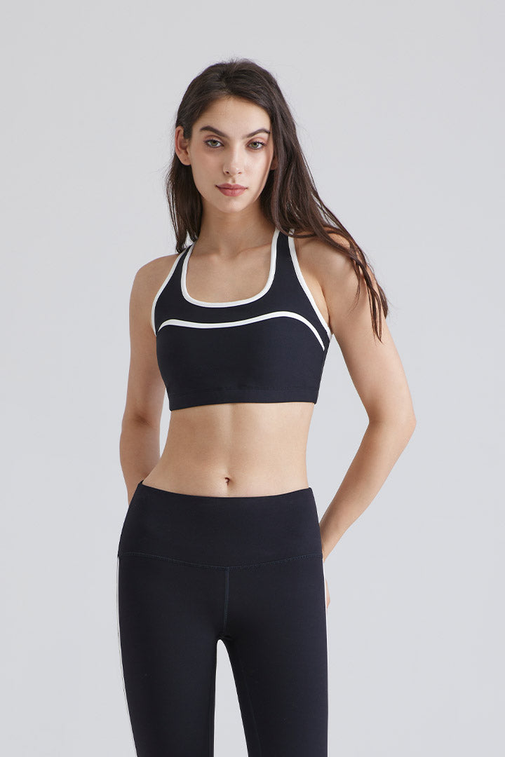 Woman wearing a black sports yoga bra and leggings