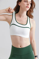Woman white sports bra with green trim and green leggings