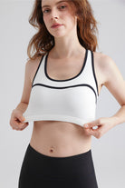 Woman wearing a white sports bra with black straps