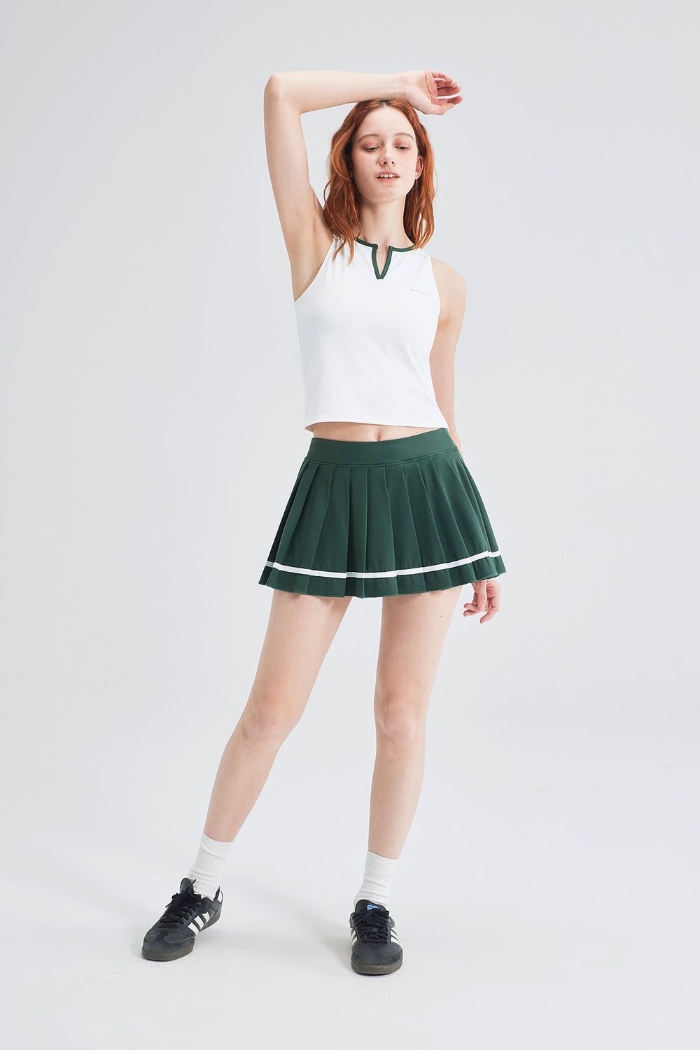 green pleated skort and white tank outfit for a cute walking outfit