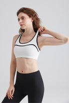 Woman wearing a white sports bra and black leggings Cait Rigor Bra racerback workout Bra
