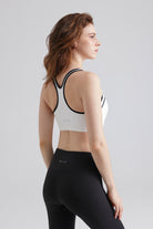 Woman wearing a white sports bra and black leggings