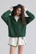 Woman green zip up hoodie for running and white skirt 