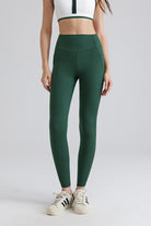 Women wearing green leggings and a white crop top with black stripes