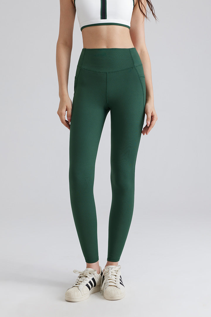 Women wearing green leggings and a white crop top with black stripes