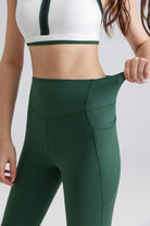 women green sports leggings and a white sports bra with green trim 