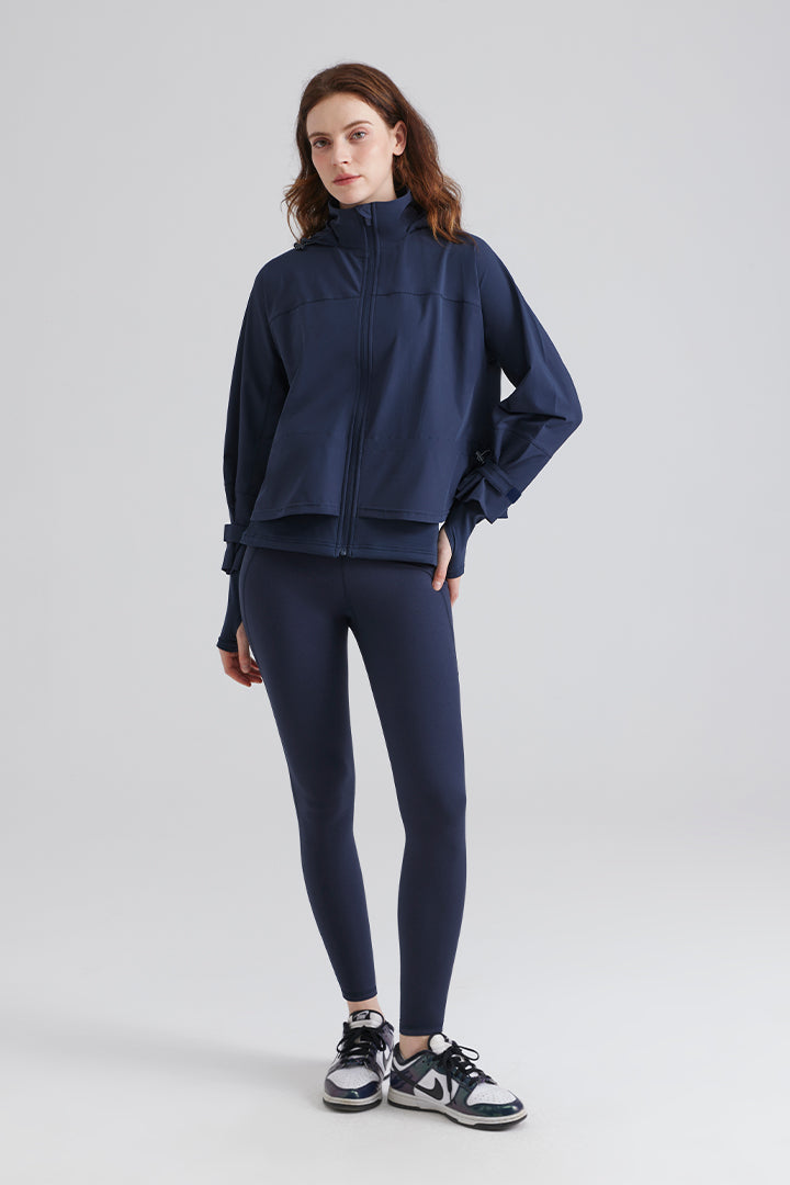 Woman wearing a navy blue jacket and leggings 