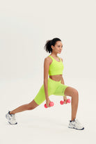Woman athletic wear performing a lunge with dumbbells