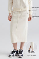 women cream-colored outfit with side pockets and back slit hem