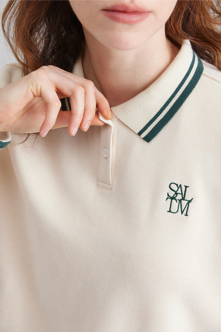 Close-up of a women wearing a beige polo sweater with collar